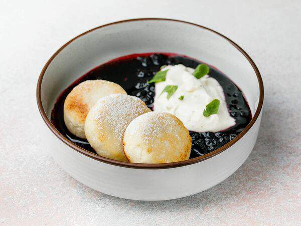 Гости - Сырники с ванильным кремом и черничным соусом