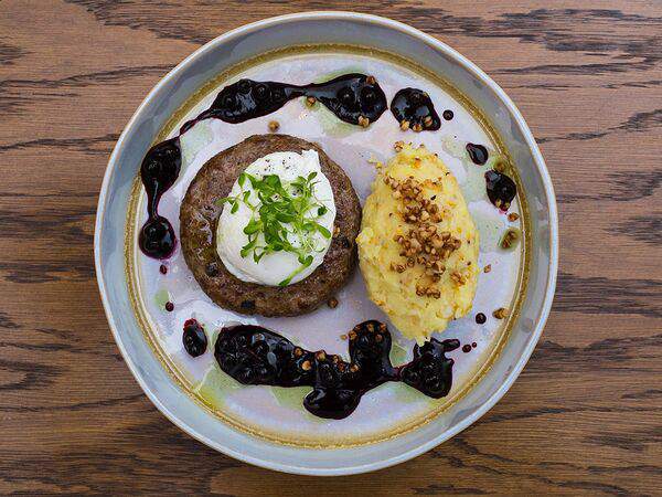 Столица деревень - Рубленый бифштекс из кабана с яйцом пашот на мятом картофеле с зернами горчицы и соусом из черники